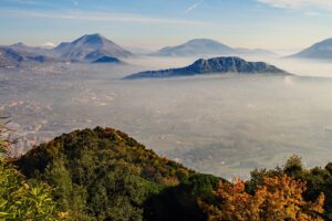 Vista panoramica del borgo di Erice avvolto nella nebbia, con castelli e dolci genovesi tipici.