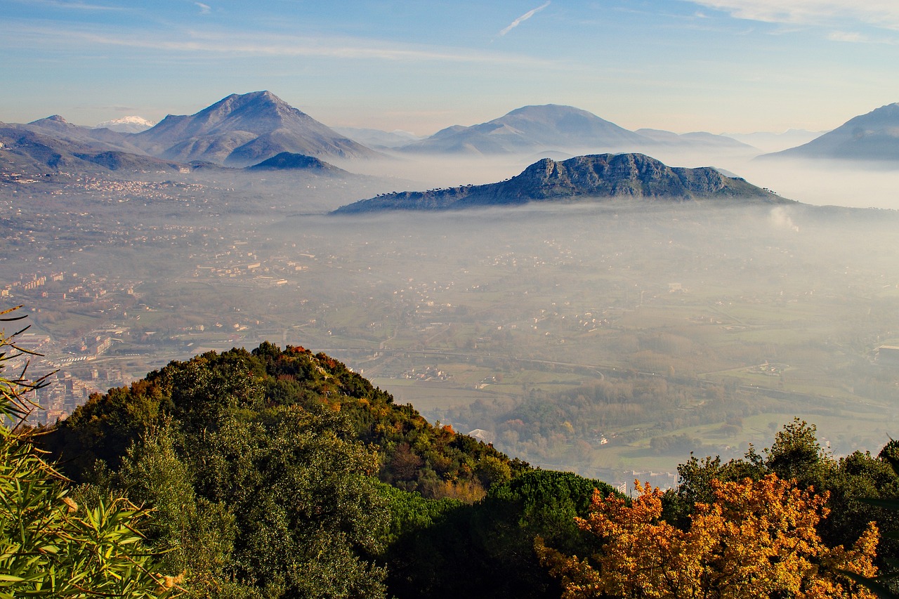 Vista panoramica del borgo di Erice avvolto nella nebbia, con castelli e dolci genovesi tipici.