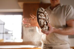Immagine di un pane appena sfornato con crosta dorata, evidenziando l'effetto del vapore nel forno.