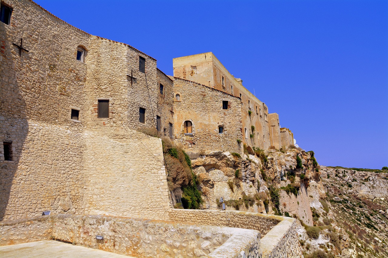 Vista panoramica del borgo di Castelsardo con la rocca e i cestini intrecciati in primo piano.