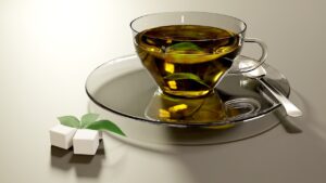 Tazza di tè verde su un tavolo, con un avviso sul possibile danno al fegato.